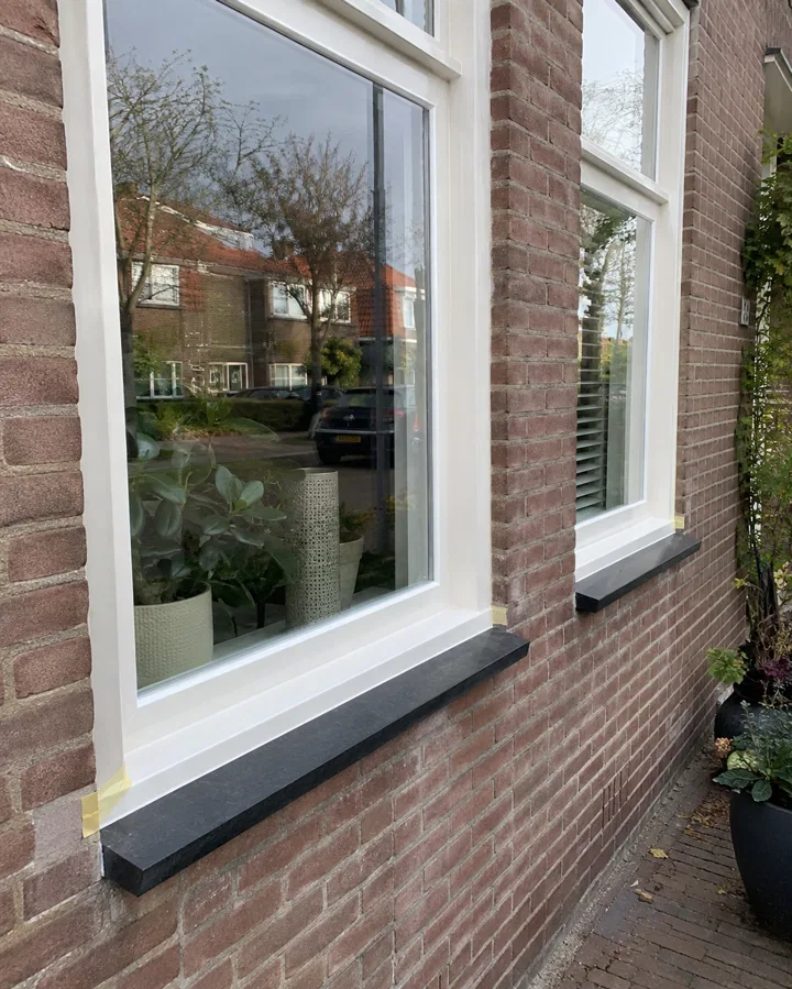 Wit geschilderde buitenkozijnen aan een woning